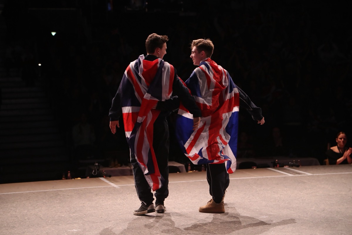 Two Team UK dancers draped in Union flags after competing